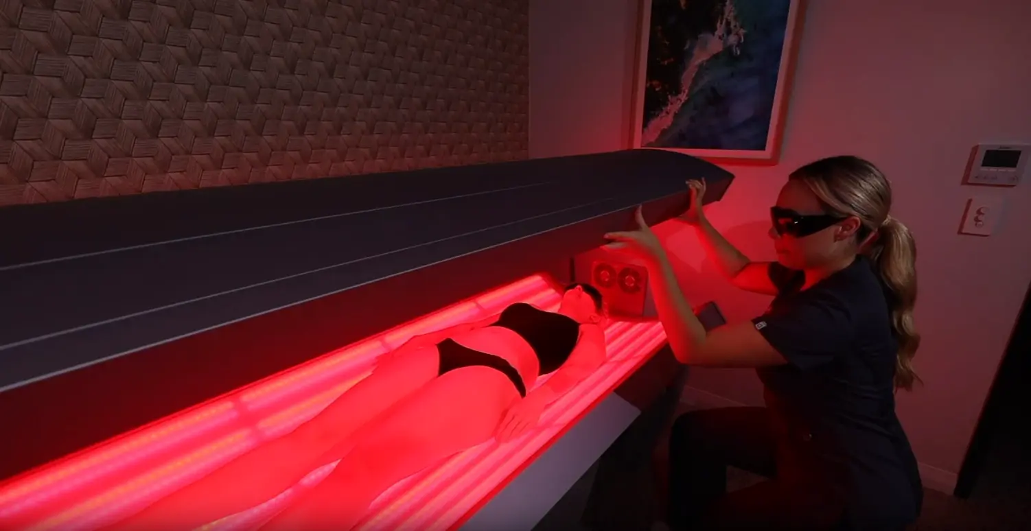 A woman is undergoing a session of LED light therapy