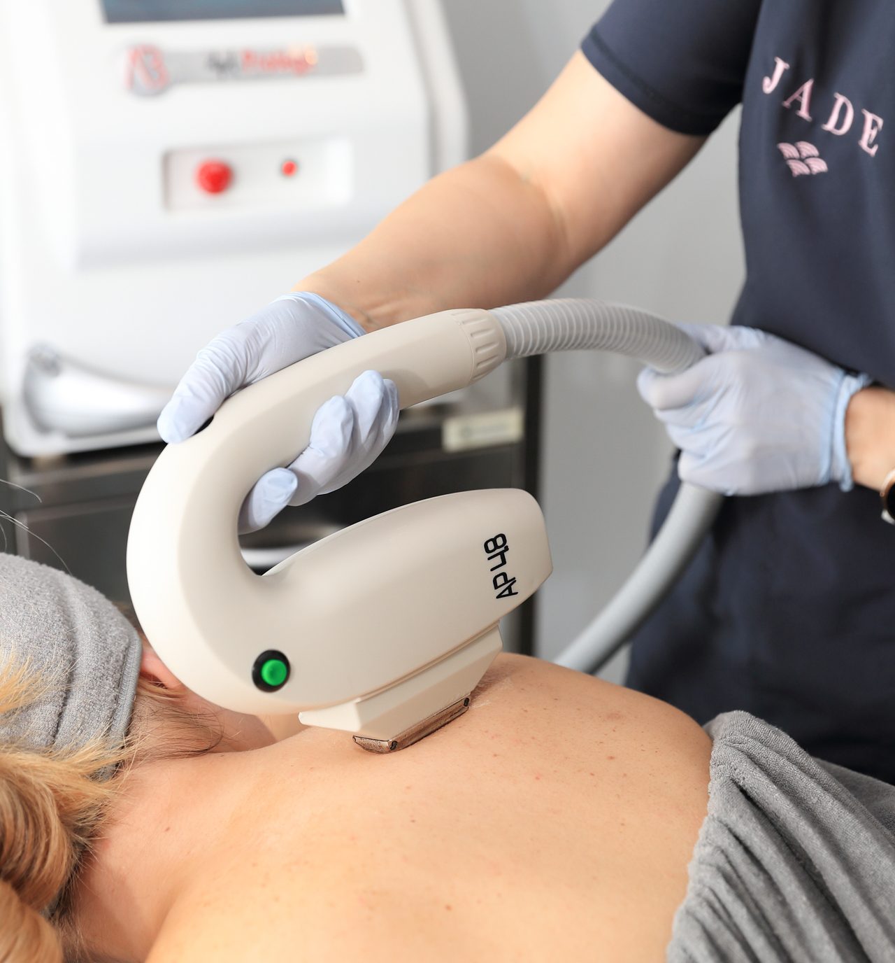 Technician performing non-invasive treatment with an advanced aesthetic device.
