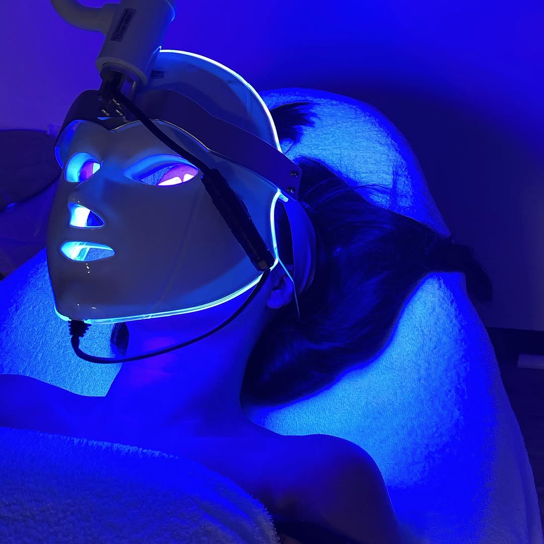 A client experiencing the deep-cleansing power of 415nm blue light – targeting acne-causing bacteria and calming inflammation with a Pearl Xen LED mask treatment.