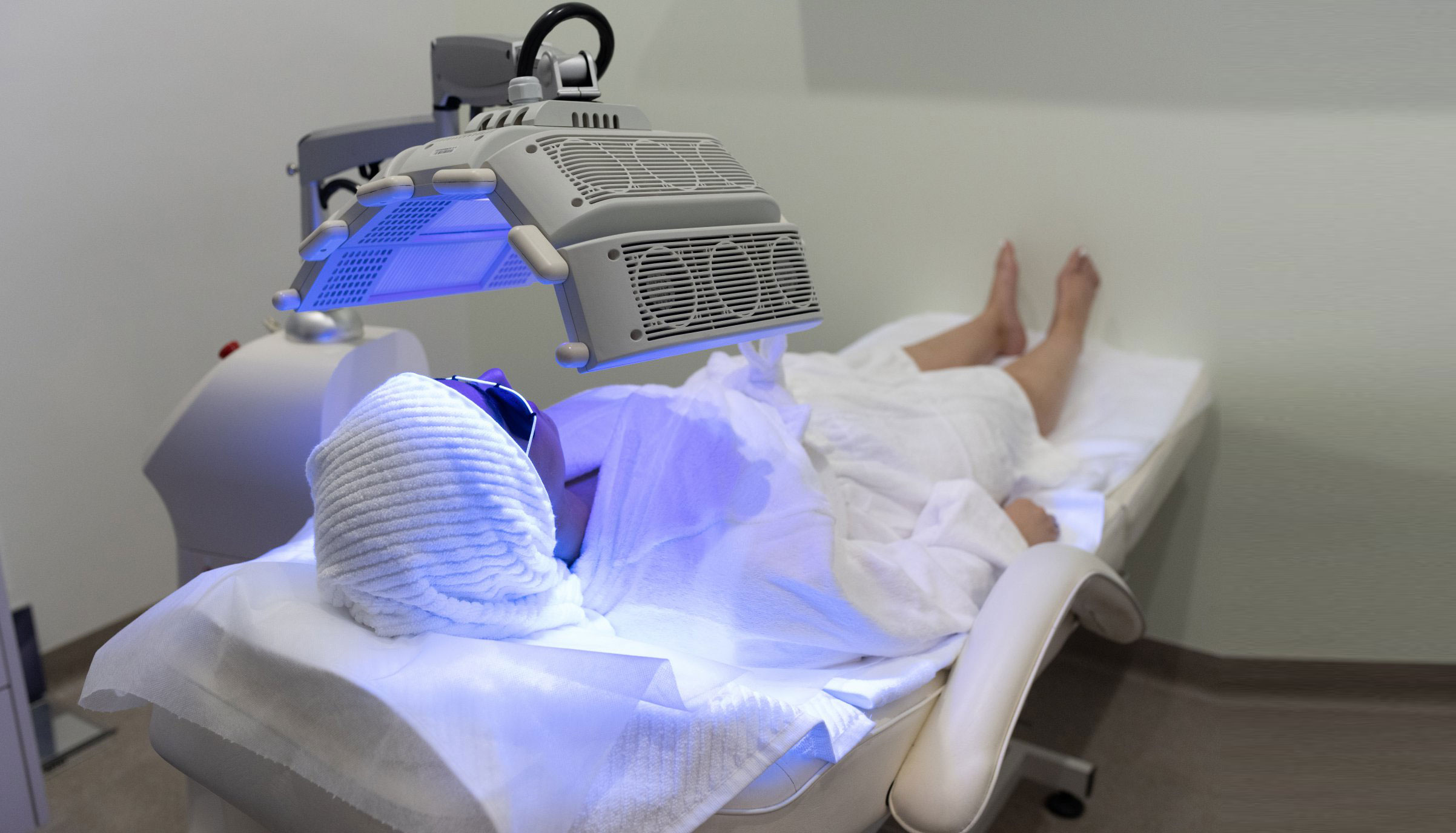 A person receiving LED light therapy at a medical aesthetics clinic.